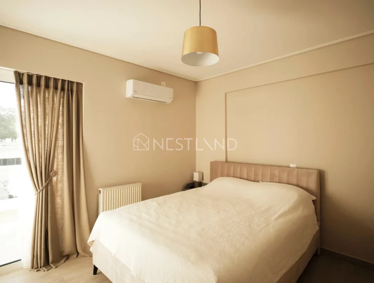 Minimalist bedroom with a beige theme, a large bed, pendant light, and an air conditioner.
