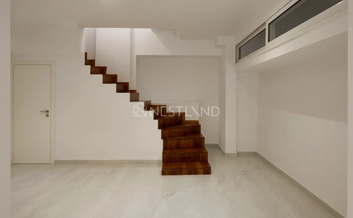 Modern interior with floating wooden staircase, white walls, and marble floor.