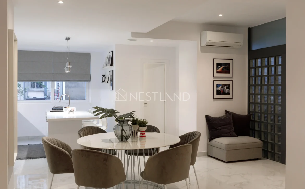 Modern kitchen and dining area with sleek design, marble flooring, and neutral tones.