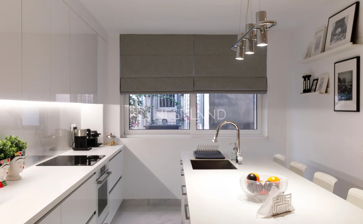 Modern kitchen interior with white cabinets, appliances, and a dining area.