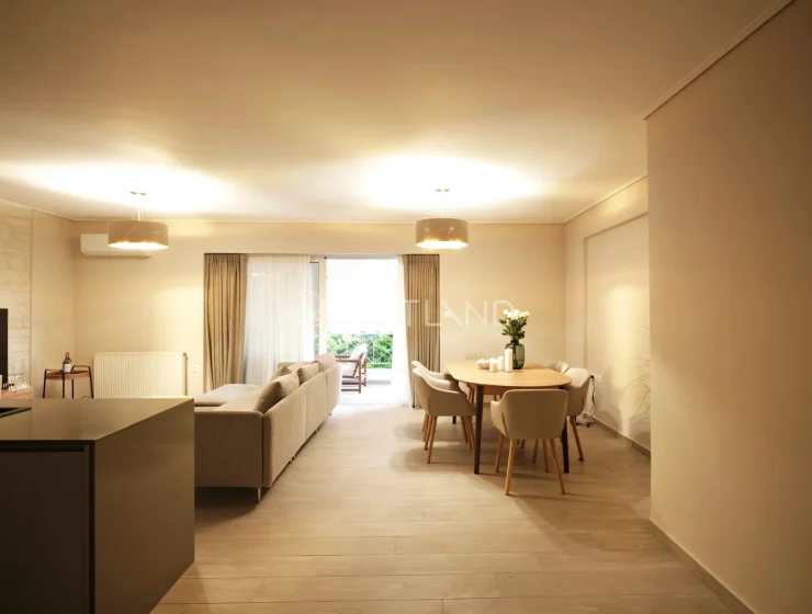 Modern living and dining area with beige tones, sofa, table, and open balcony door.