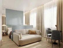Modern living space with sofa, dining area, and sheer curtains.