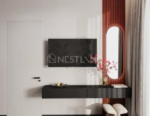 Modern living room corner featuring a black wall-mounted TV, minimalist console with fruit, and a stylish red-striped accent wall.