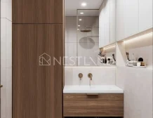 Modern bathroom featuring warm wood cabinetry, dual faucets, a sleek sink, and stylish ambient lighting.