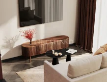 A cozy living room featuring a beige sofa, a dark coffee table with candles, and a stylish wooden TV stand with a decorative red plant.